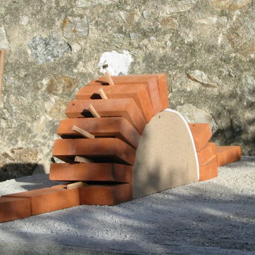Les cales de bois maintiennent l'écartement des briques avant la prise du mortier
